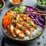 Delicious Bang Bang Chicken Bowl served with fresh vegetables and spicy sauce.