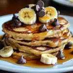 Fluffy chocolate chip oatmeal pancakes stacked on a plate.