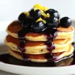 Fluffy lemon ricotta pancakes topped with homemade blueberry syrup