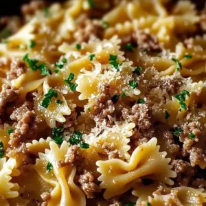 Garlic Butter Bowtie Pasta topped with seasoned ground beef on a plate