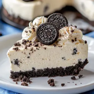 No-bake Fireworks Oreo cheesecake bars topped with colorful sprinkles and Oreo cookies.