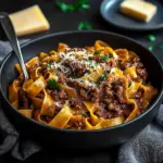 Delicious bowl of Short Rib Ragu with pasta, garnished with herbs.