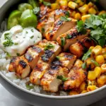 Delicious street corn chicken rice bowl topped with fresh herbs and spices.